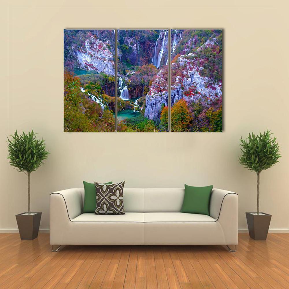 Cascading Waterfalls in Autumn Forest Canvas Wall Art in gray, orange and green, 3 panel horizontal set hung on a wall