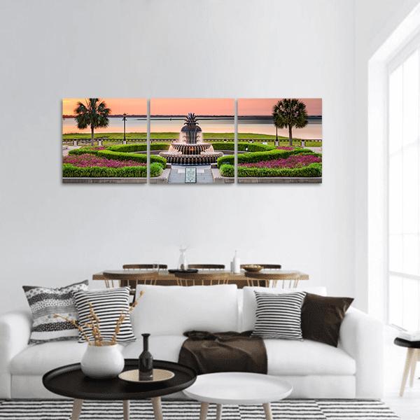 Pineapple Fountain at Dusk Panoramic Canvas Wall Art in orange, green and pink, hung on a wall