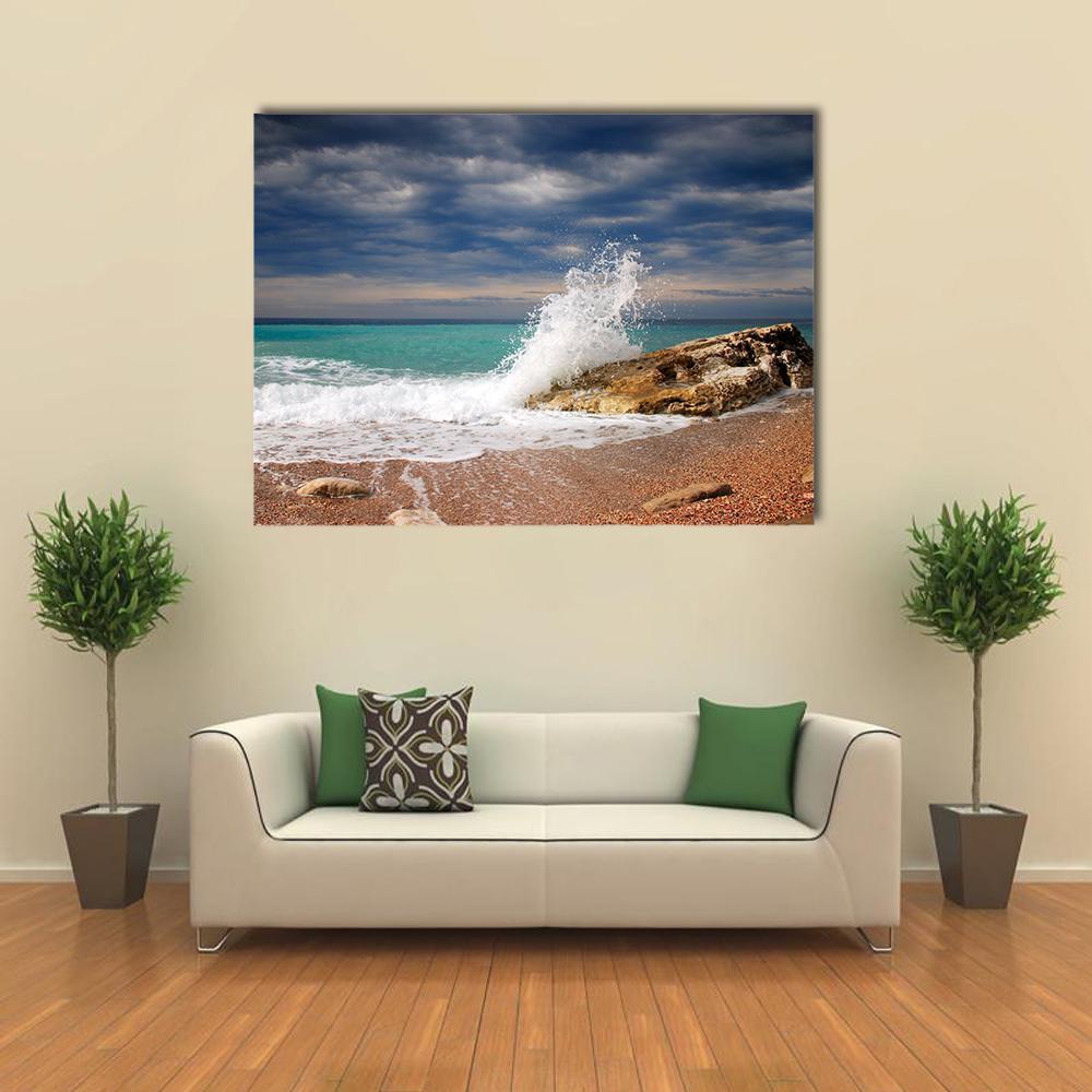 Crashing Wave on Rocky Shore Canvas Wall Art in white, brown and blue, single panel hung on a wall