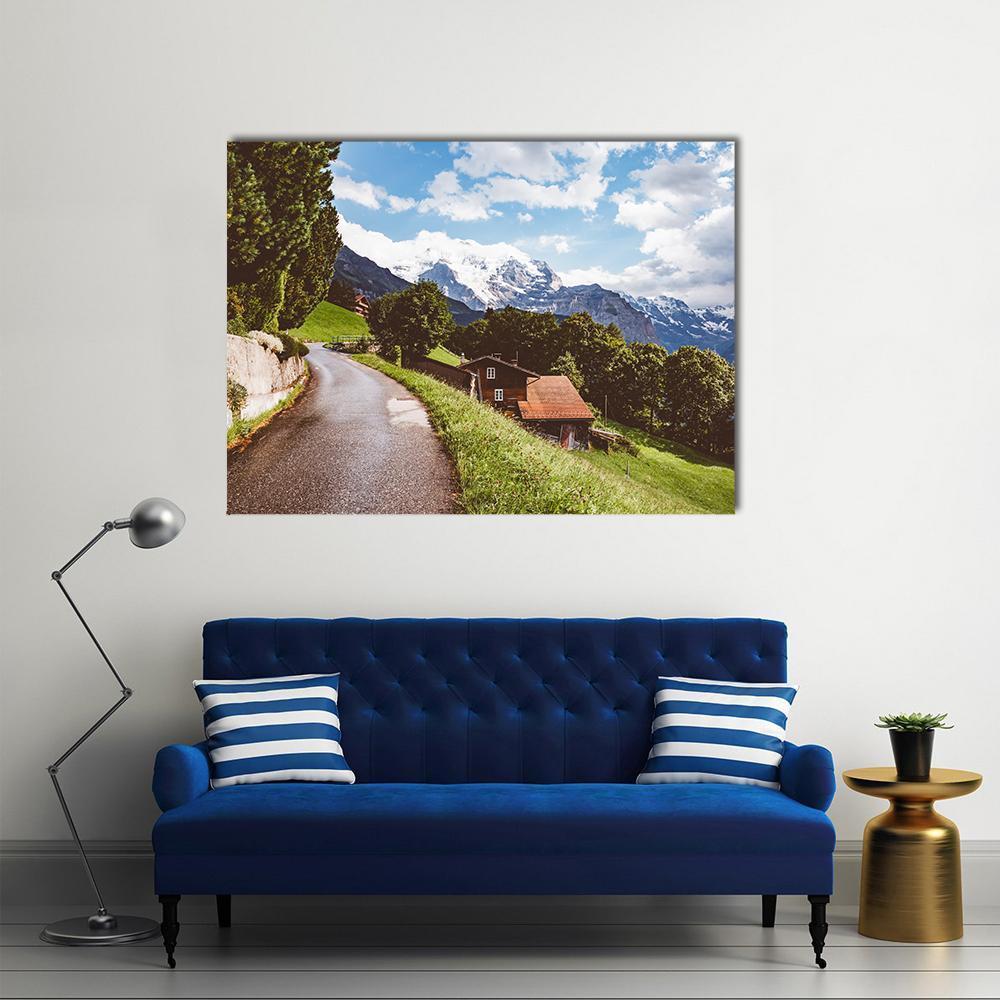 Mountain Road Through Alpine Village Canvas Wall Art in white, green and blue, single panel hung on a wall