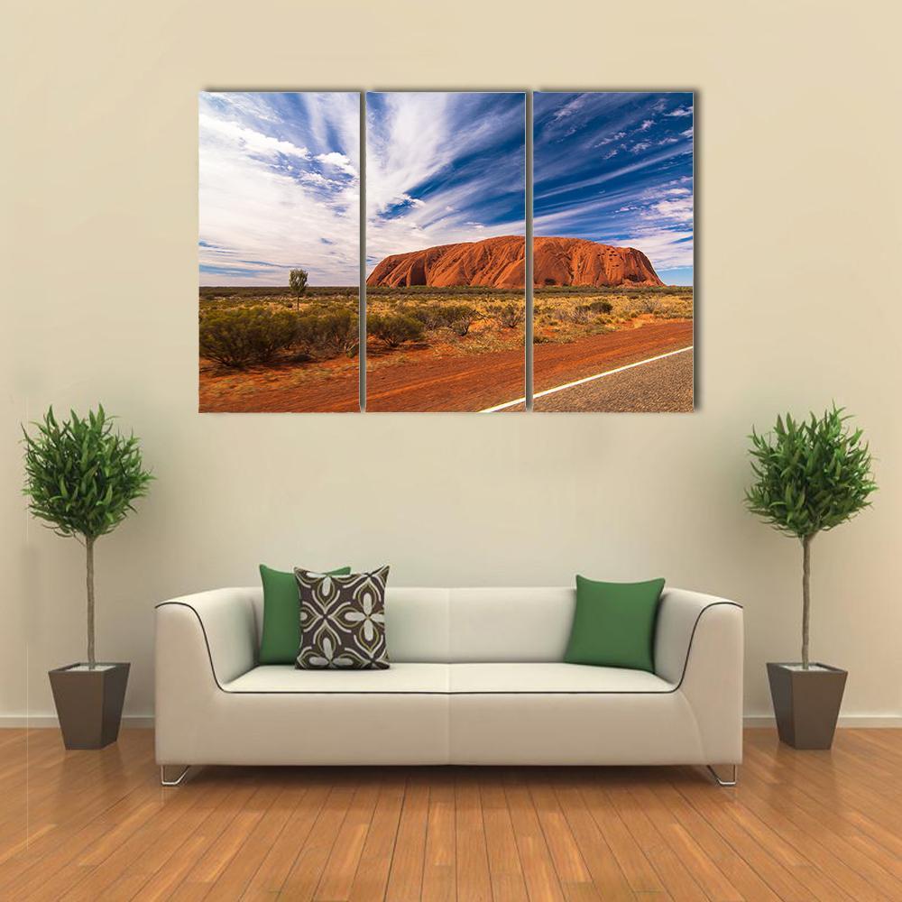 White Clouds Over Uluru Canvas Wall Art in white, orange and blue, 3 panel horizontal set hung on a wall