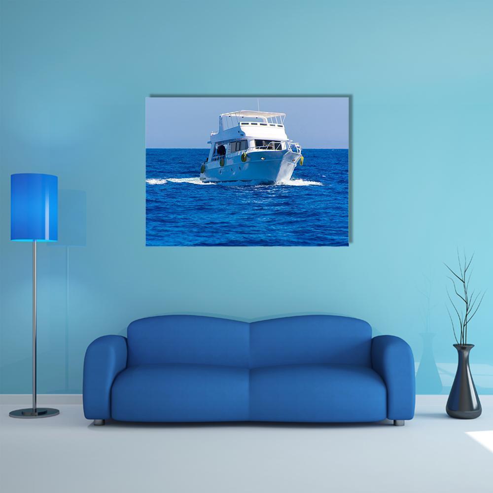 White Motor Yacht on Blue Water Canvas Wall Art in white and blue, single panel hung on a wall