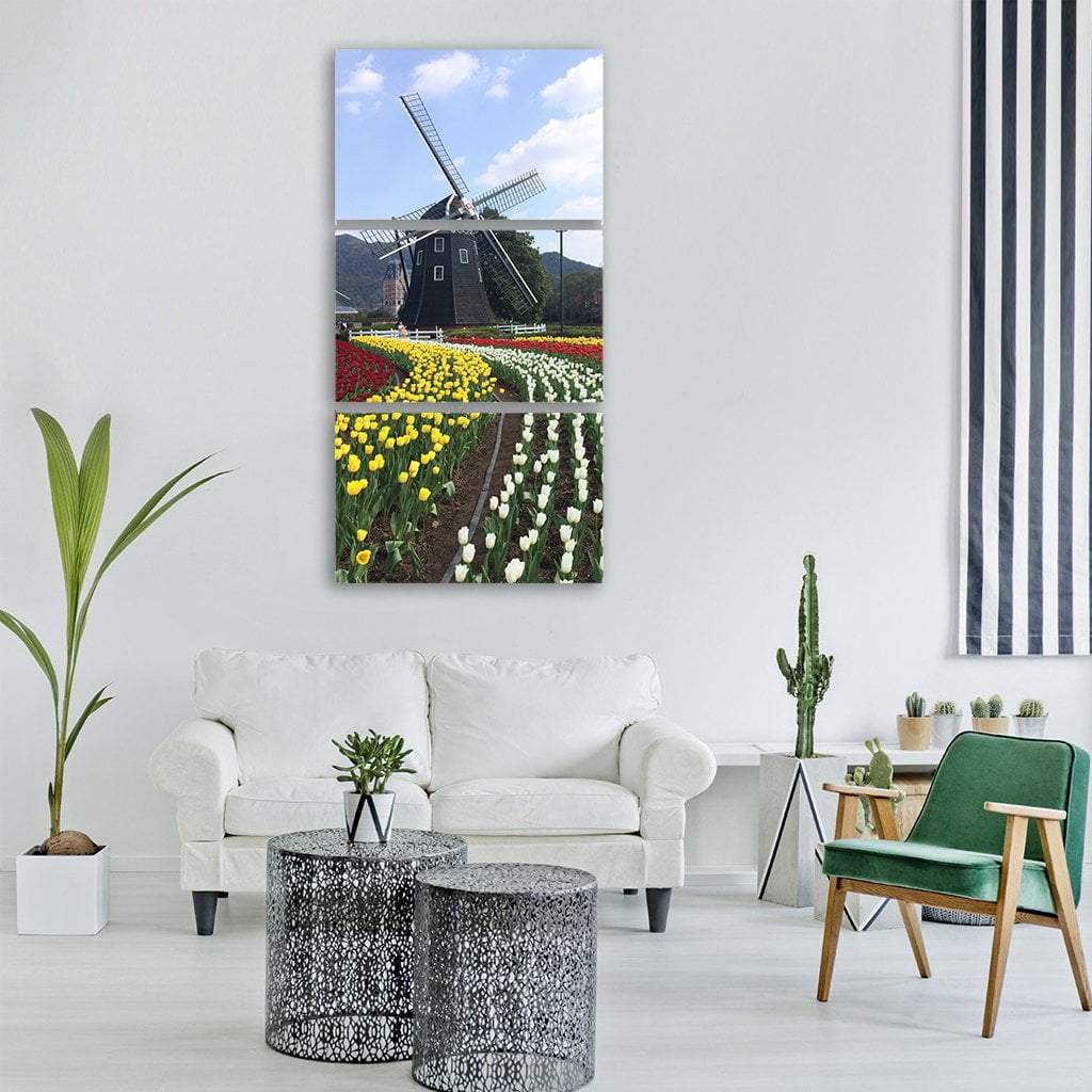 Dutch Windmill Among Spring Tulips Vertical Canvas Wall Art in yellow, green and blue, single vertical panel hung on a wall