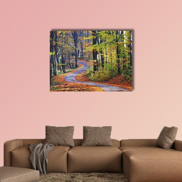 Winding Path Through Autumn Forest Canvas Wall Art in brown, orange and yellow, single panel hung on a wall