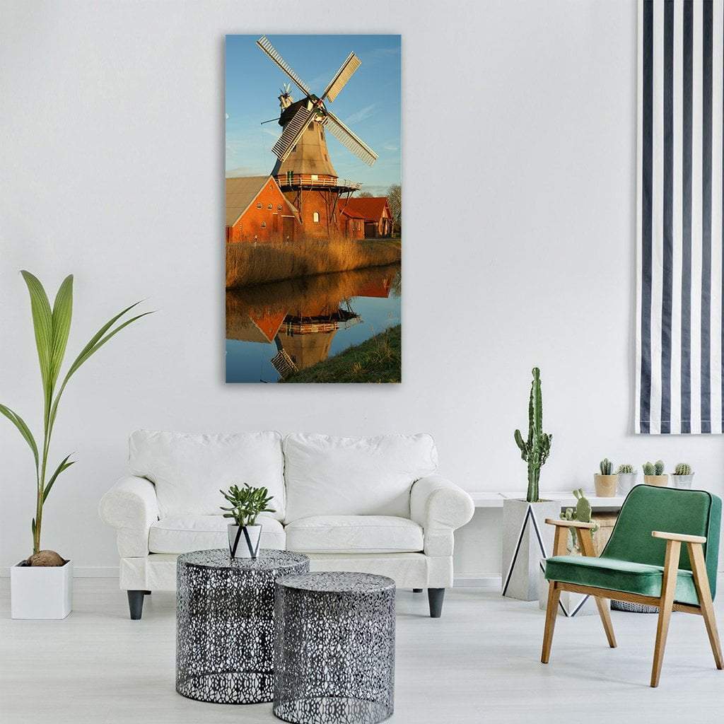 Windmill Reflected in Canal at Sunset Vertical Canvas Wall Art in brown, orange and blue, single vertical panel hung on a wall