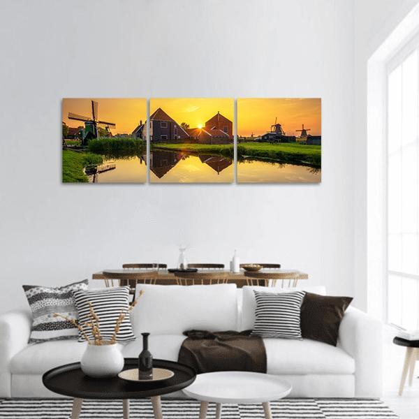 Dutch Windmills at Sunset Panoramic Canvas Wall Art in orange, yellow and green, hung on a wall