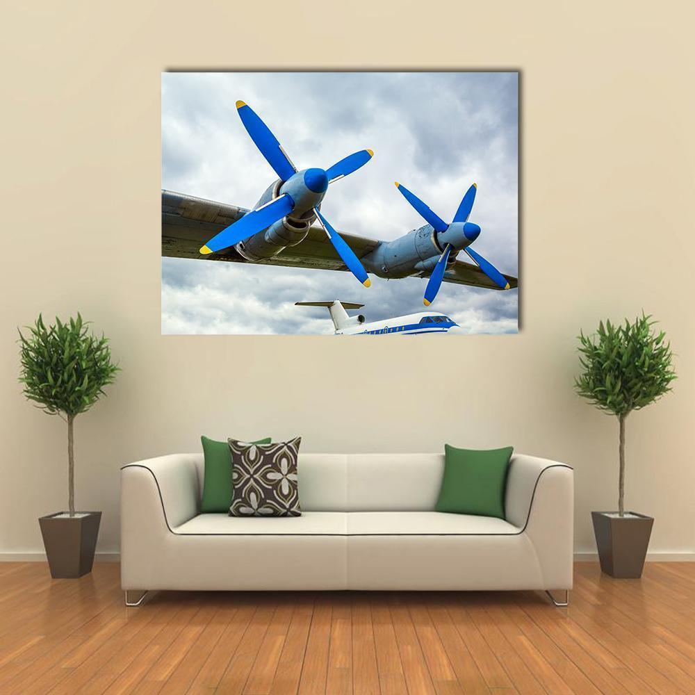 Turboprop Wing with Blue Propellers Canvas Wall Art in white, gray and blue, single panel hung on a wall