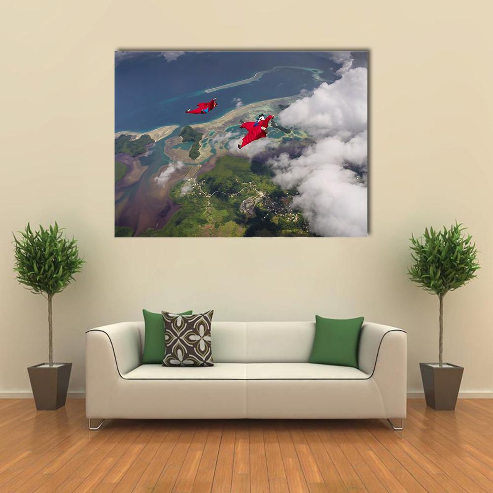 Two Wingsuit Flyers Over Island Coast Canvas Wall Art in white, green and blue, single panel hung on a wall