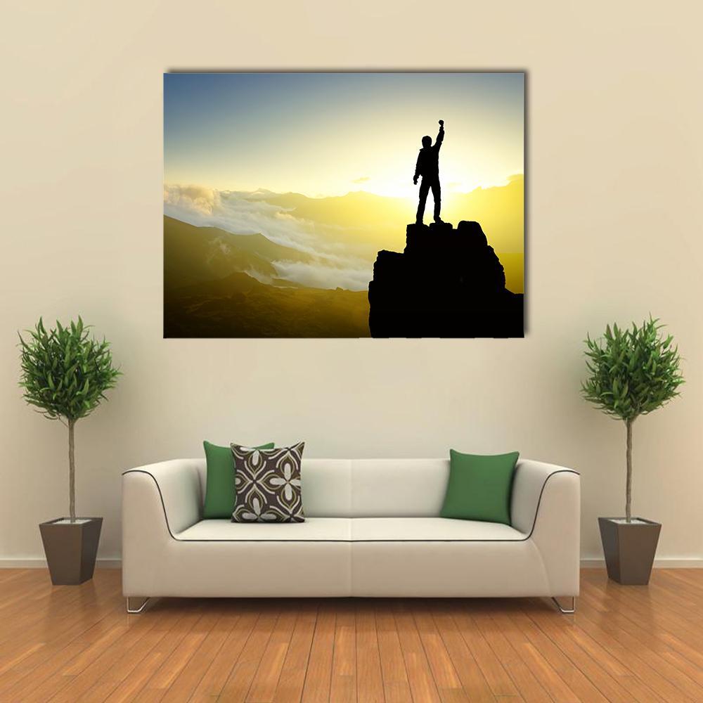 Victorious Silhouette on Mountain Peak Canvas Wall Art in black, yellow and blue, single panel hung on a wall