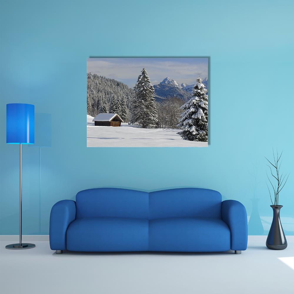 Alpine Winter Cabin Landscape Canvas Wall Art in white, gray and blue, single panel hung on a wall