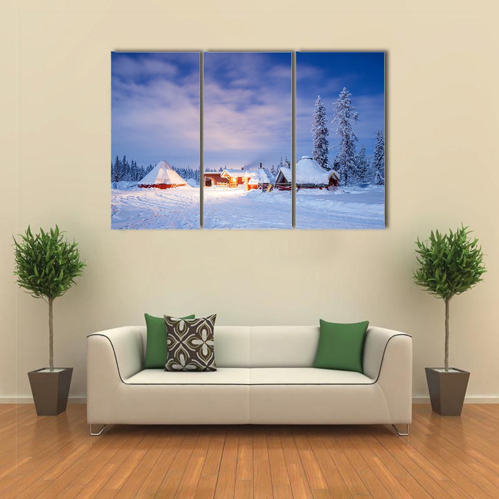 Winter Landscape with Cabin at Night Canvas Wall Art in white and blue, 3 panel horizontal set hung on a wall