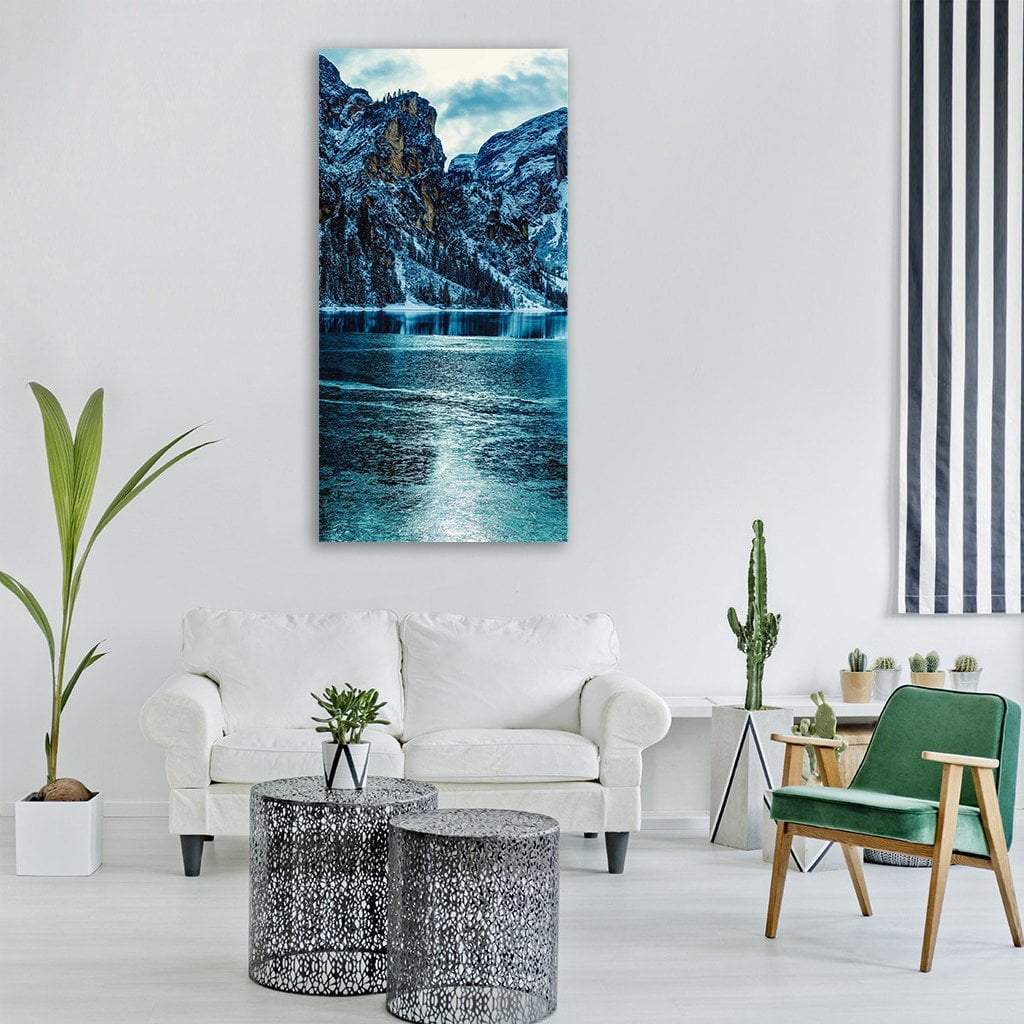 Snow-dusted Mountains Over a Lake Vertical Canvas Wall Art in white, gray and blue, single vertical panel hung on a wall
