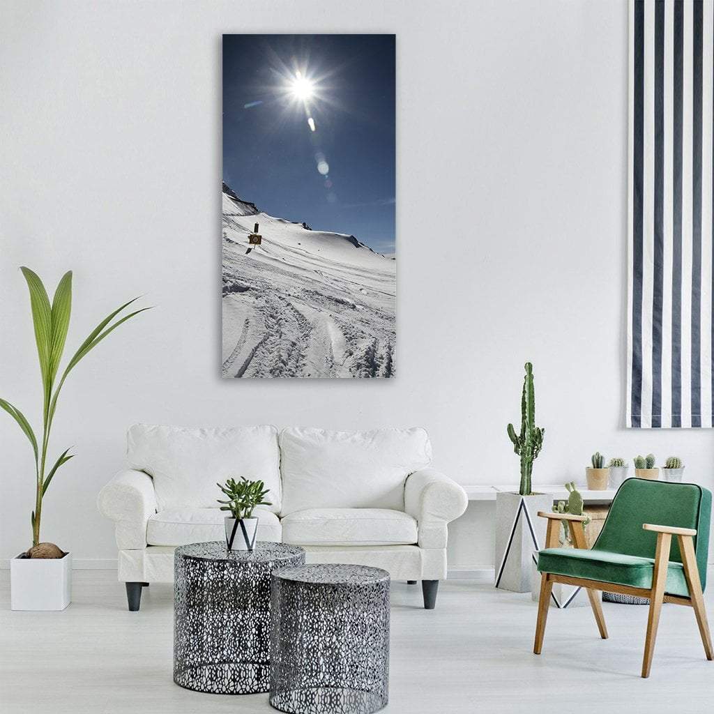 Snowy Mountain with Ski Tracks and Sunburst Vertical Canvas Wall Art in white and blue, single vertical panel hung on a wall