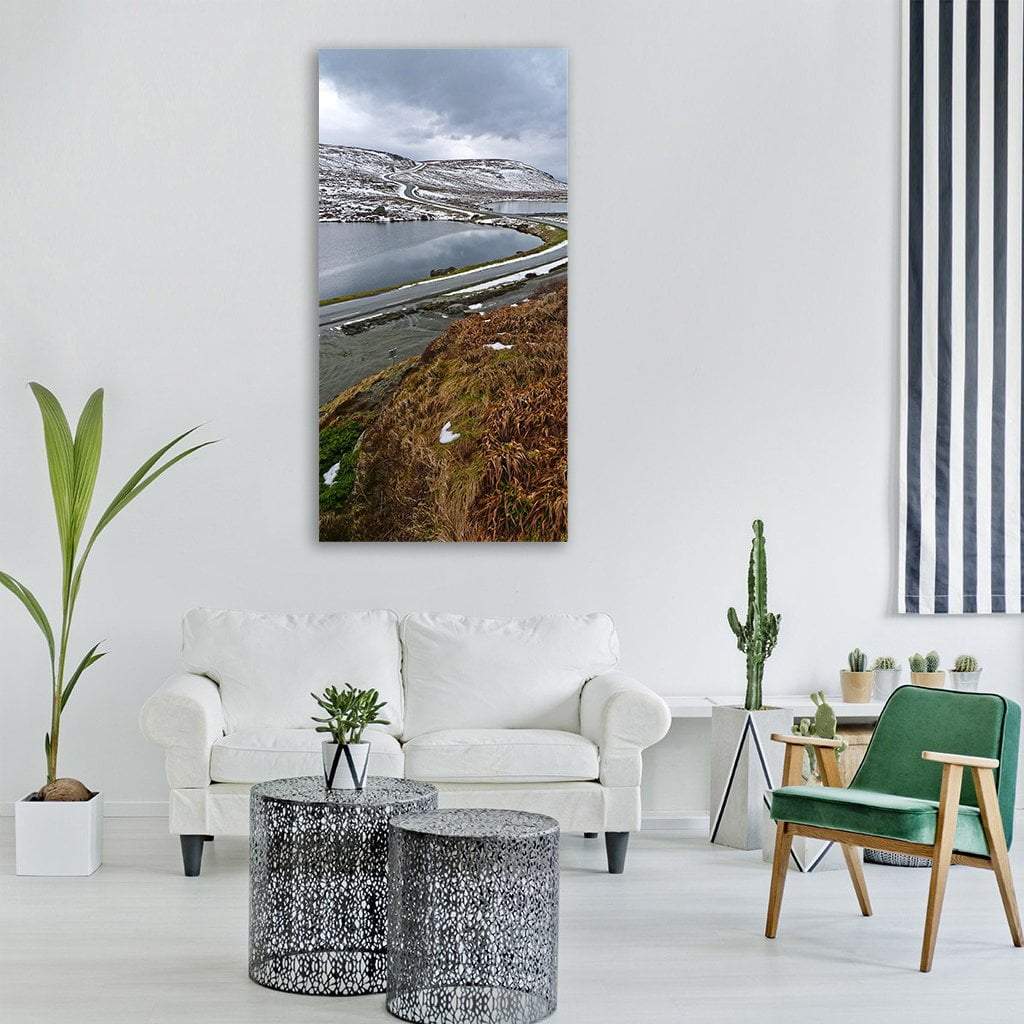 Winter Snow on Mountain Road Vertical Canvas Wall Art in white, gray and brown, single vertical panel hung on a wall