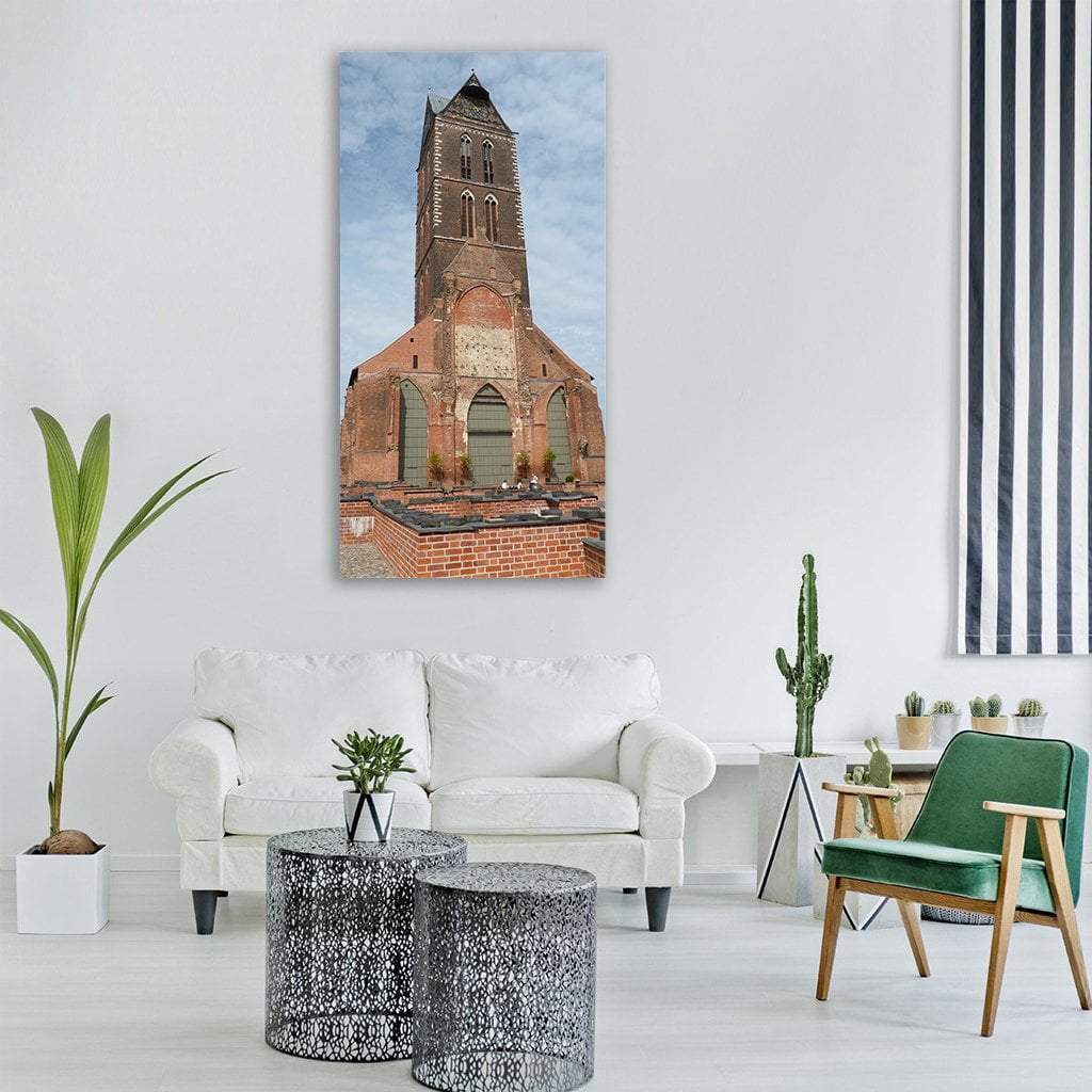 Gothic Church Tower with Brick Steeple Vertical Canvas Wall Art in brown, orange and blue, single vertical panel hung on a wall