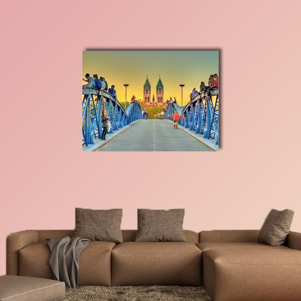 Wiwili Bridge in Freiburg at Sunset Canvas Wall Art in orange, yellow and blue, single panel hung on a wall