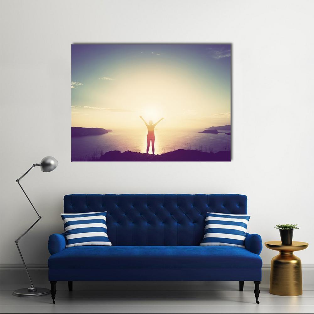 Woman on Cliff at Sunset Canvas Wall Art in yellow, blue and purple, single panel hung on a wall