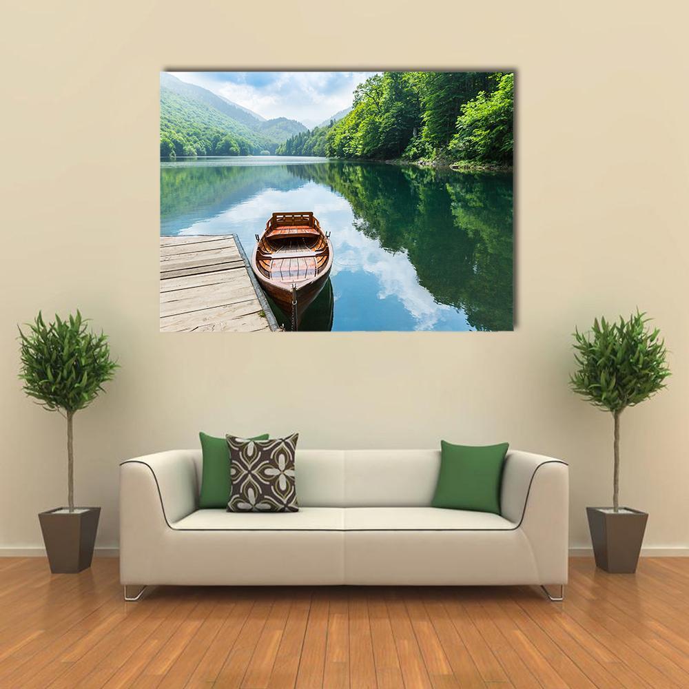 Wooden Boat at Mountain Lake Pier Canvas Wall Art in brown, green and blue, single panel hung on a wall