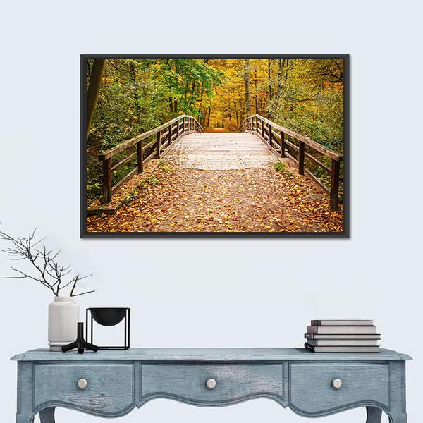 Wooden Bridge in the Autumn Forest Canvas Wall Art in brown, yellow and green, framed canvas, product view on a white background