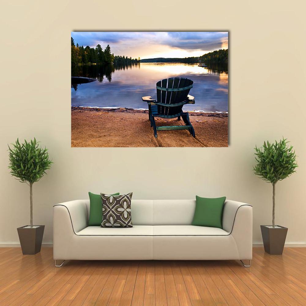 Weathered Adirondack Chair at Lakeside Sunset Canvas Wall Art in brown, orange and blue, single panel hung on a wall