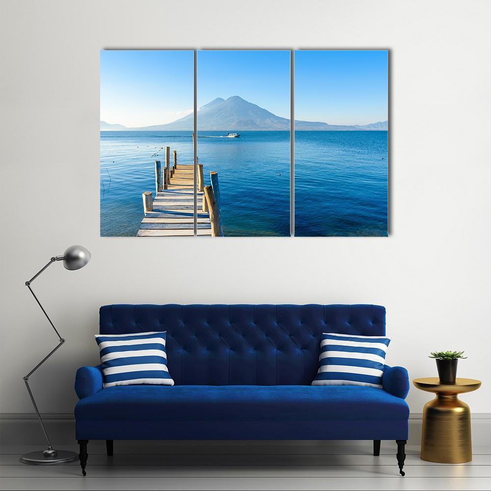 Wooden Pier at Lake Atitlan Canvas Wall Art in brown and blue, 3 panel horizontal set hung on a wall