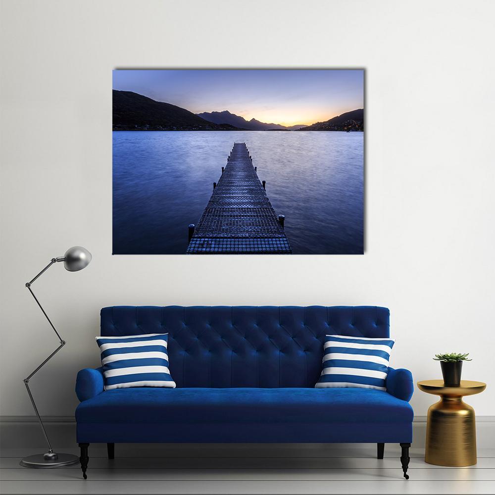 Wooden Pier on Lake at Twilight Canvas Wall Art in orange, blue and navy, single panel hung on a wall