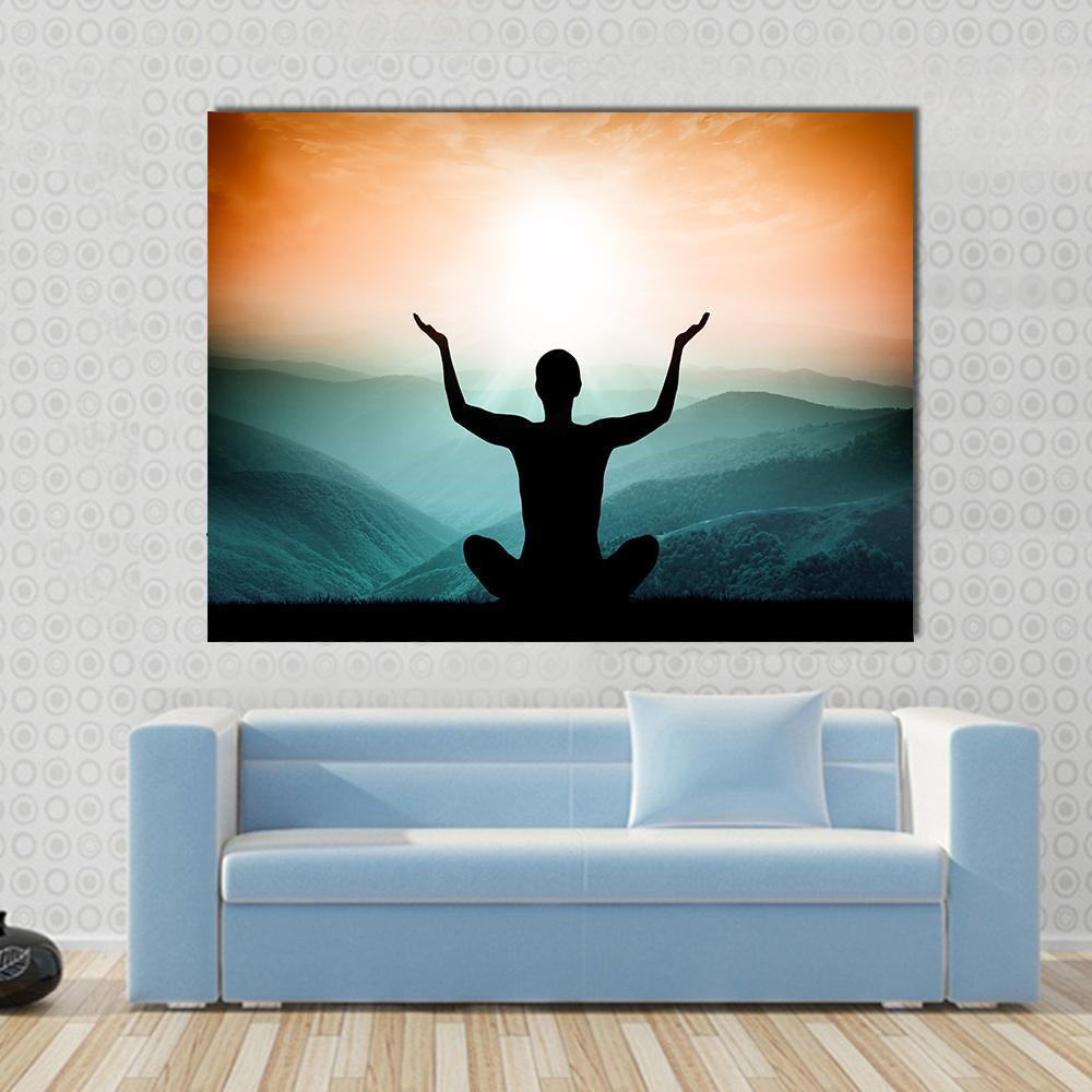 Yoga and Meditation Silhouette Canvas Wall Art in black, orange and blue, single panel hung on a wall