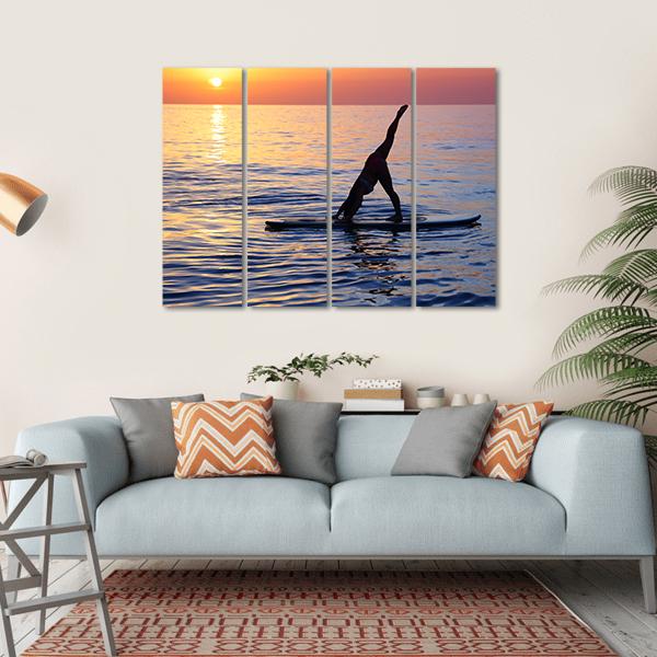 Paddleboard Yoga at Sunset Canvas Wall Art in orange, yellow and blue, hung on a wall