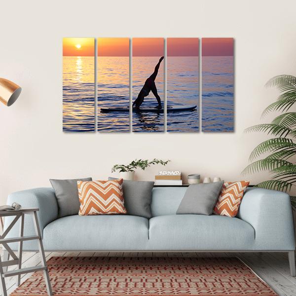 Paddleboard Yoga at Sunset Canvas Wall Art in orange, yellow and blue, single panel hung on a wall