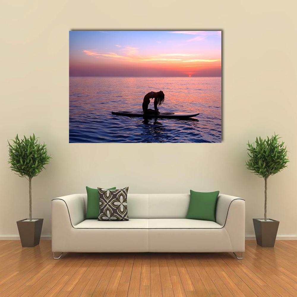 Sunset Paddleboard Yoga Backbend Canvas Wall Art in orange, blue and pink, single panel hung on a wall