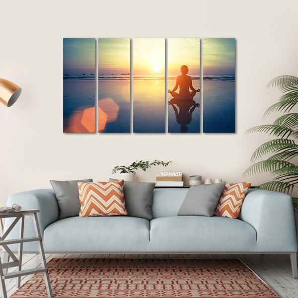 Yoga Woman at Sunset Canvas Wall Art in orange, yellow and blue, hung on a wall