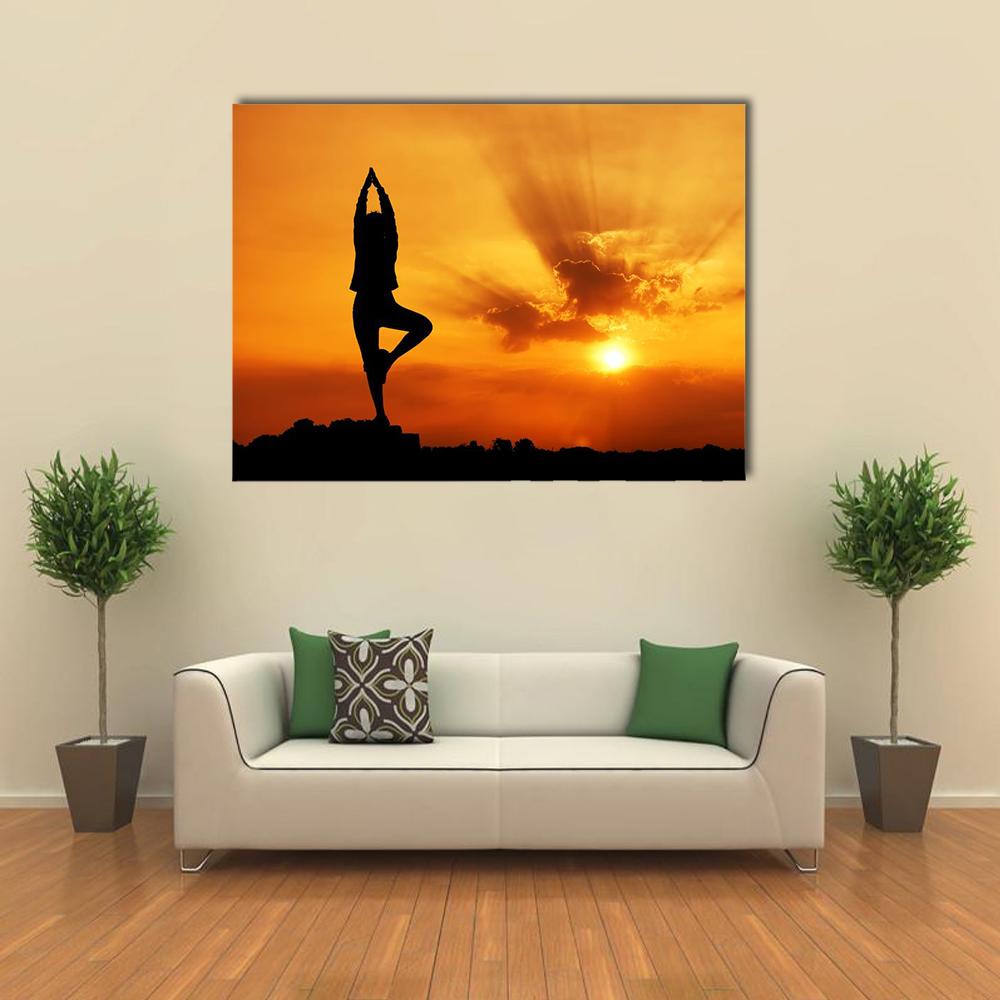 Tree Pose Silhouette at Sunset Canvas Wall Art in black, orange and yellow, single panel hung on a wall