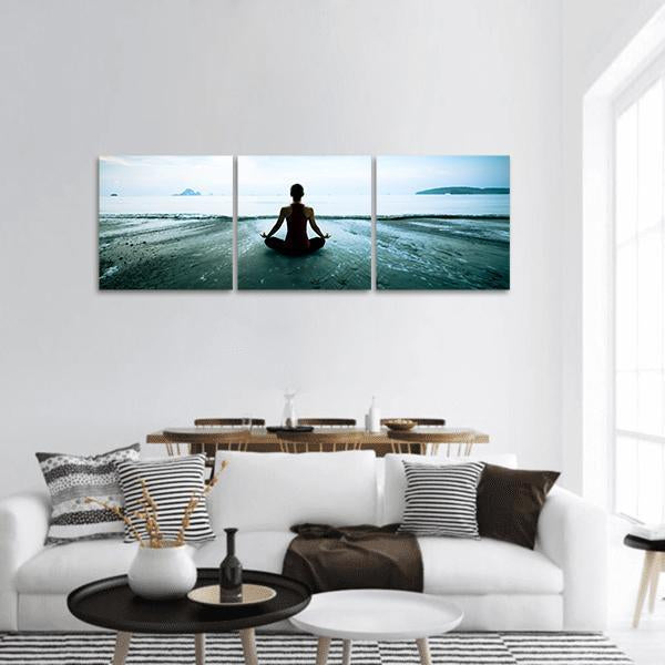 Woman Meditating on Beach Panoramic Canvas Wall Art in white, gray and blue, hung on a wall