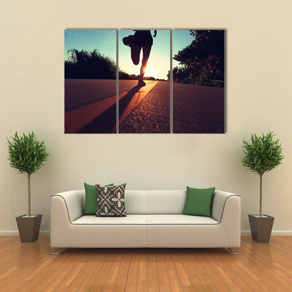 Young Runner at Sunrise Canvas Wall Art in black, orange and yellow, 3 panel horizontal set hung on a wall