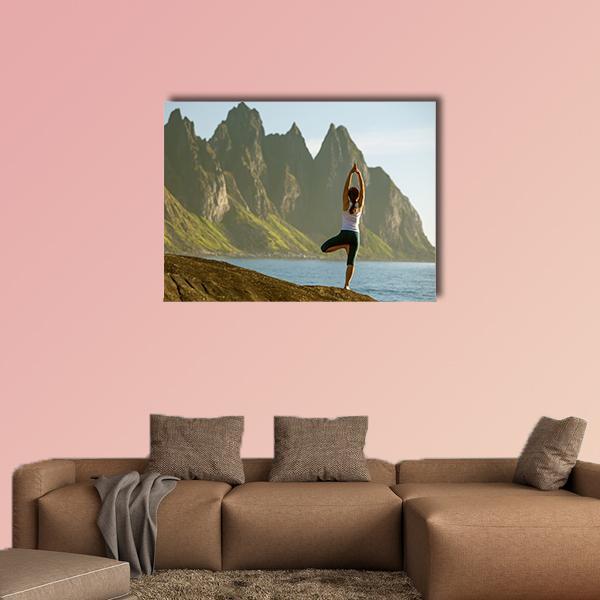 Young Woman in Tree Pose on Coastal Cliffs Canvas Wall Art in brown, green and blue, single panel hung on a wall