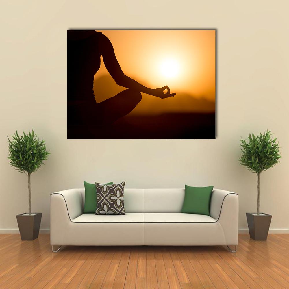 Young Women Meditating at Sunset Canvas Wall Art in black, orange and yellow, single panel hung on a wall