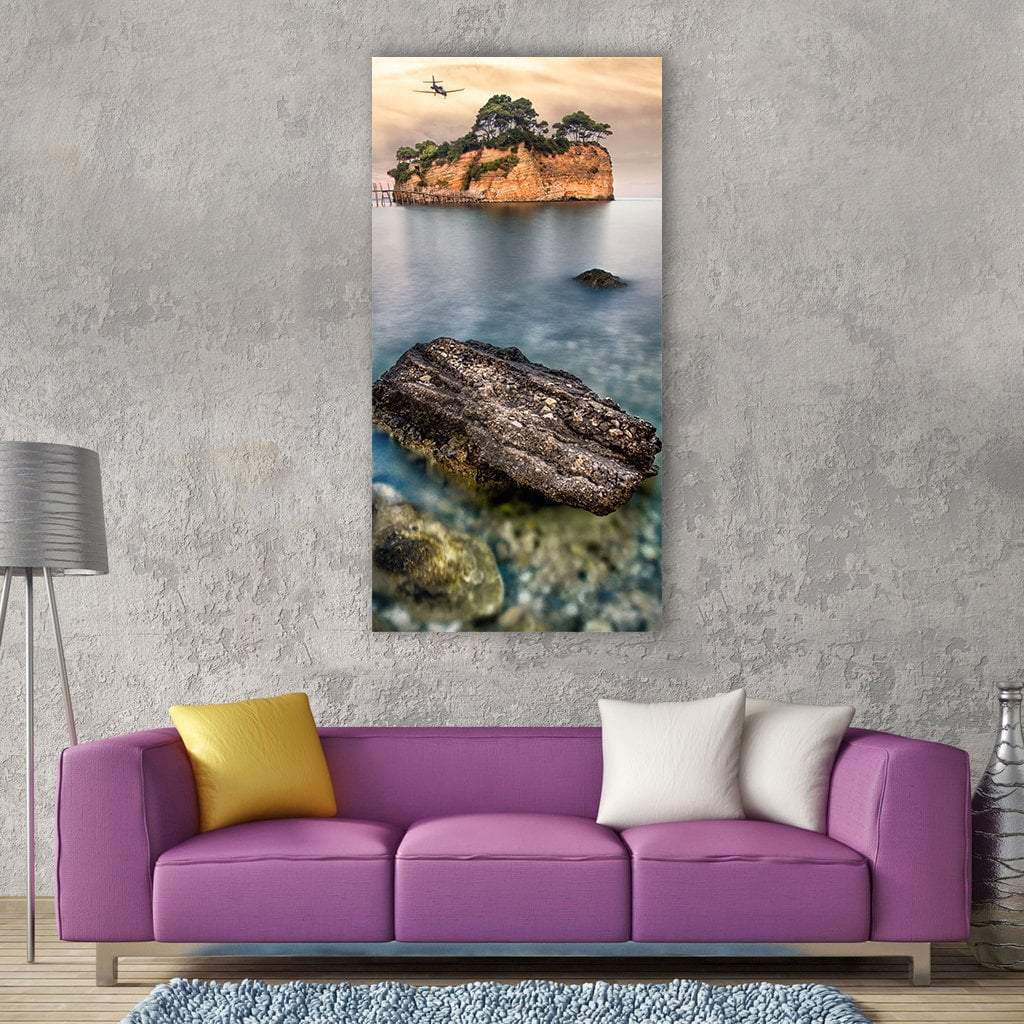Tree-covered Island with Pier and Rock Vertical Canvas Wall Art in beige, brown and blue, single vertical panel hung on a wall