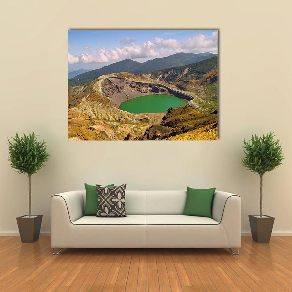 Green Crater Lake with Layered Mountains Canvas Wall Art in brown, green and blue, single panel hung on a wall